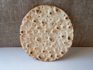 Close-up to round crispbread on white/textile background