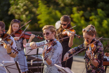 Musical ensemble playing violin at outdoor concert