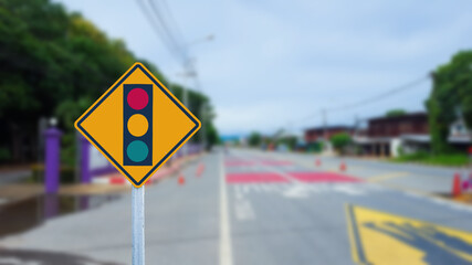 Traffic light sign beside road on blur background