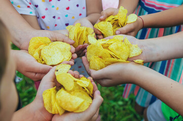 Children eat chips on the street. Selective focus.