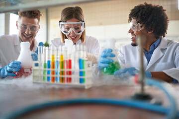Happy lab technicians looking biochemical reaction