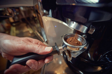 Fototapeta na wymiar A measure of ground coffee taken into the handle for making espresso. Coffee, beverage, bar