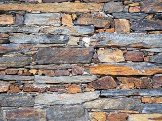 Wall of slate. Background os slate stones of different size and shape put in layers