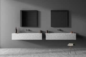 Grey bathroom wall with two square mirrors