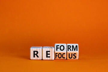 Refocus and reform symbol. Businessman turned cubes and changed the word 'refocus' to 'reform'....