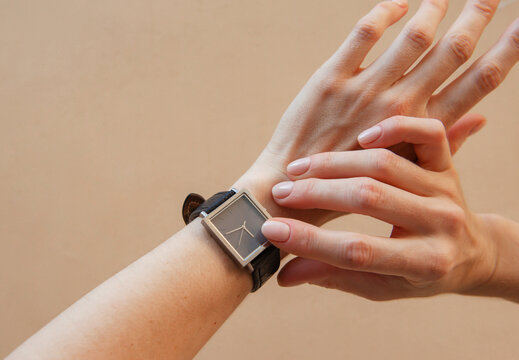 female hands show time on black watch