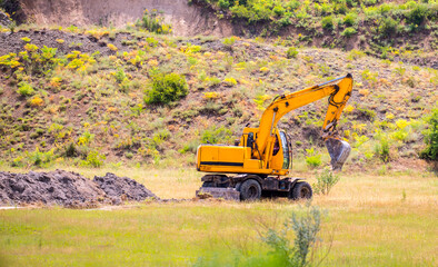 Excavator in the working process digs the ground digger. Works on gravel mining career.