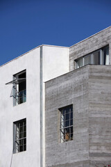 Low angle view of a section of a simple minimalist office building under blue sky