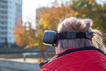 woman in virtual reality glasses in front of the city, AR City Guide