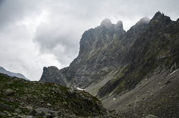 Amazing natural landscape with stones with rocks in fog and cloudy sky in the misty summer day. Mountain peaks in the Tatra Mountains, Slovakia