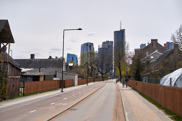 One lane street. Skyscrapers at the end of the street. 