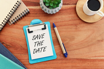 Top view image of table and note with the text – save the date