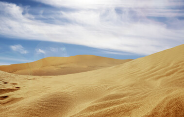 Picturesque view of sandy desert and blue sky on hot sunny day