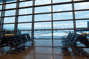 Empty seats at departure lounge, no people. International airport interior