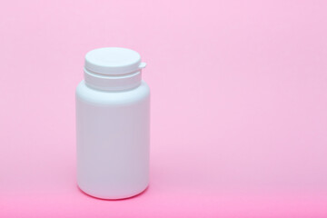 White different medecine or cosmetic jars on a pink background as a concept of cosmetology of medecine and treatment