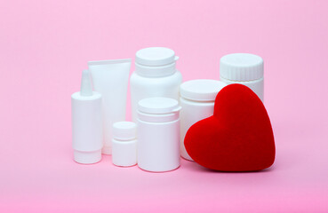 White different medecine or cosmetic jars on a pink background as a concept of cosmetology of medecine and treatment