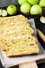 Apple and coconut loaf cake on wooden cutting board