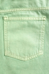 Light green jeans with back pocket as background, closeup
