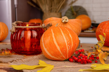 A pumpkin-shaped lamp is lit on a table decorated for Halloween.