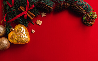 Christmas composition. Fir tree branches and Christmas decor on red background. New year, Christmas, winter, winter holidays concept. Flat lay, top view, copy space, space for text. 