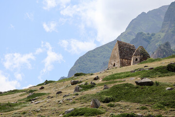 Old abandoned ancient tombs in "city of dead" necropolis in Eltubu, Chegem Valley, Caucasus, Russia with beautiful sky on background