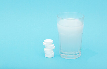 Glass with clean water cool on a blue background with effervescent tablets vitamins or medicine