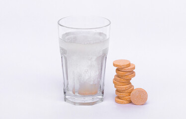 Glass with water on a white background with effervescent tablets vitamins