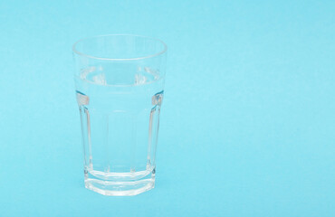 A glass with pure cool water on a blue background