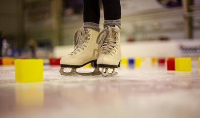 Little girl learns to skate. Children's skates. A child training on ice. The concept of children's figure skating. Children's sports. Winter sport