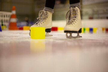 Little girl learns to skate. Children's skates. A child training on ice. The concept of children's...