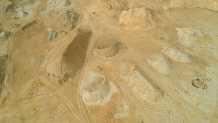 Open pit gravel mining. Large piles of construction sand and gravel used for asphalt production and building. Limestone quarry, mining rocks and stones photographed from above with a drone. 