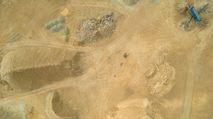 Open pit gravel mining. Large piles of construction sand and gravel used for asphalt production and building. Limestone quarry, mining rocks and stones photographed from above with a drone. 