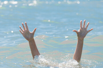 A hands from under the water of a drowning girl, help and urgent rescue of a person during a...