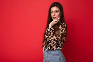 Close-up portrait of young nice-looking attractive lovely glamorous brunet woman wearing leopard blouse isolated on red color background with free space