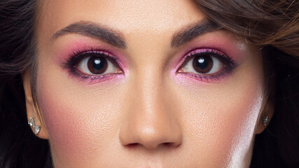 Beautiful macro of expressive brown eyes with fashionable pink smoky shadows, extremely long eyelashes. Cosmetology, eyebrow correction, eyelash extensions, makeup, cosmetics, eyesight, contact lenses