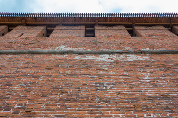 Looking from below at the brick wall of an ancient fortress. The pattern is visible on the edge of...