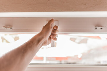 The guy's hand opens a plastic double window for the handle pvc double glazing