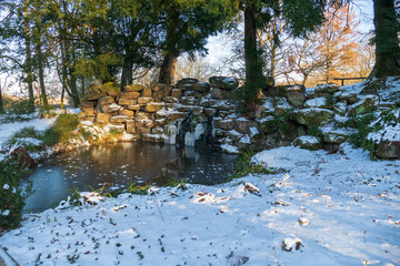 Kleiner eingefrorener Wasserfall am Schloß Favorite im Winter