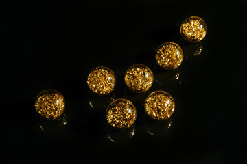 beads with golden sequins on a black mirror background