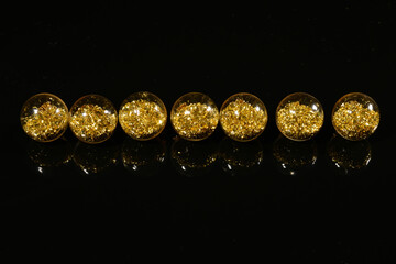 beads with golden sequins on a black mirror background