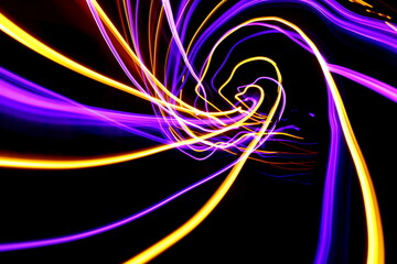 Long exposure photograph of neon colour in an abstract swirl, parallel lines pattern against a black background. Light painting photography.