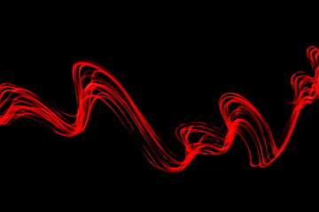 Long exposure photograph of neon red colour in an abstract swirl, parallel lines pattern against a black background. Light painting photography.