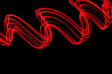 Long exposure photograph of neon red colour in an abstract swirl, parallel lines pattern against a...