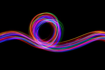 Long exposure photograph of neon colour in an abstract swirl, parallel lines pattern against a black background. Light painting photography.