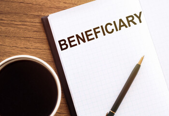 BENEFICIARY - text on notepad on wooden desk.