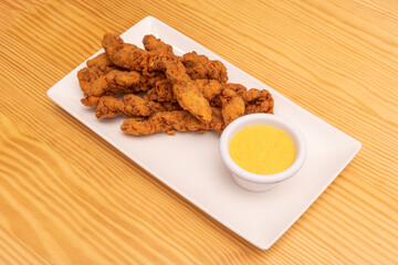 Chicken fingers coated in flour, egg and breadcrumbs, fried in olive oil and with a sweet curry sauce for dipping