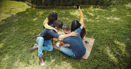 Indian friends taking selfie in a garden surrounded by trees