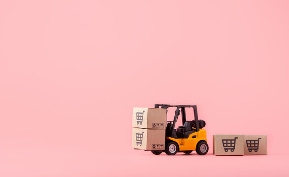Logistics, and delivery service - Forklift model and paper cartons or parcel with a shopping cart logo on Pink background. Shopping service on The online web and offers home delivery.