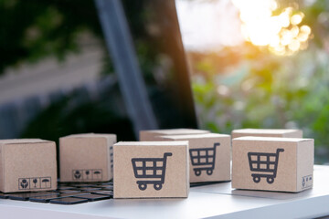 Online shopping - Paper cartons or parcel with a shopping cart logo on a laptop keyboard. Shopping service on The online web and offers home delivery..