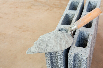 Cement powder or mortar with  trowel put on the Concrete brick for construction work..
